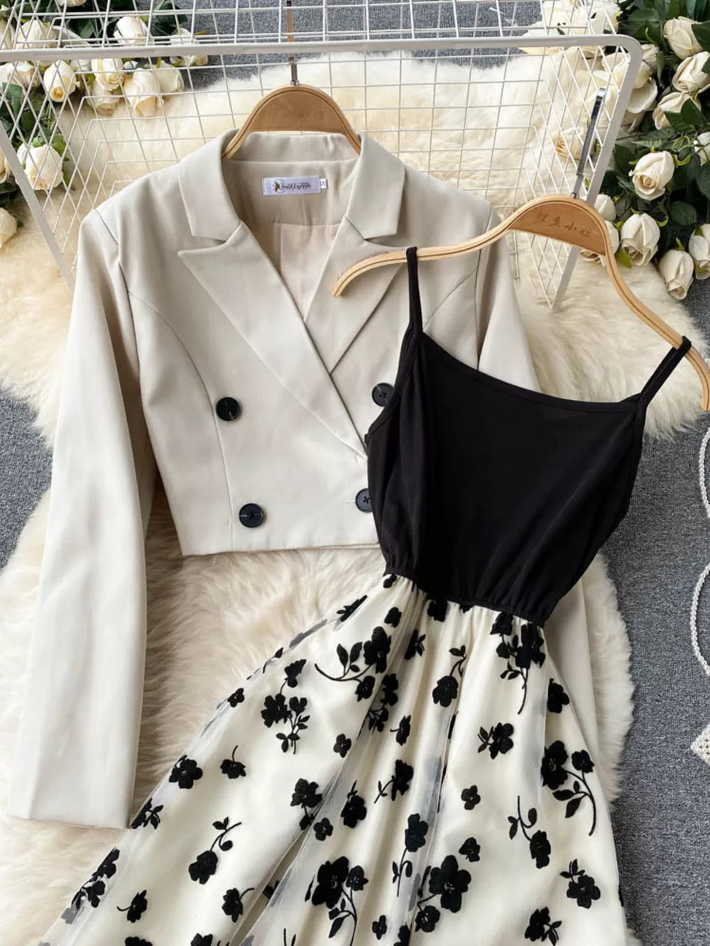 Black floral overlay midi dress with spaghetti straps paired with a cream double-breasted blazer.