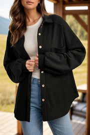 Black waffle knit shacket with gathered sleeves and button front, styled with a white top and jeans.