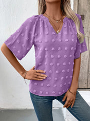 Heliotrope purple Swiss dot blouse with short sleeves and a V-neckline.