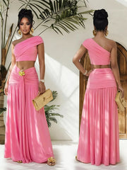 Pink one-shoulder ruched crop top and maxi skirt set with gold accent detail.