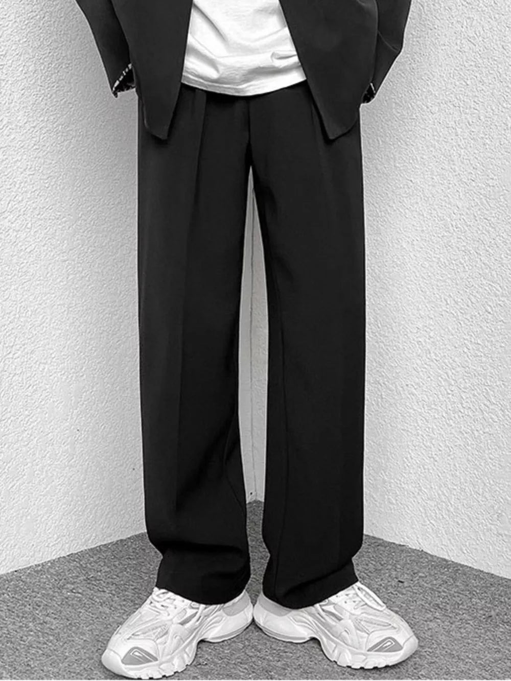 Black wide-leg casual pants with a relaxed fit, styled with a blazer and sneakers.