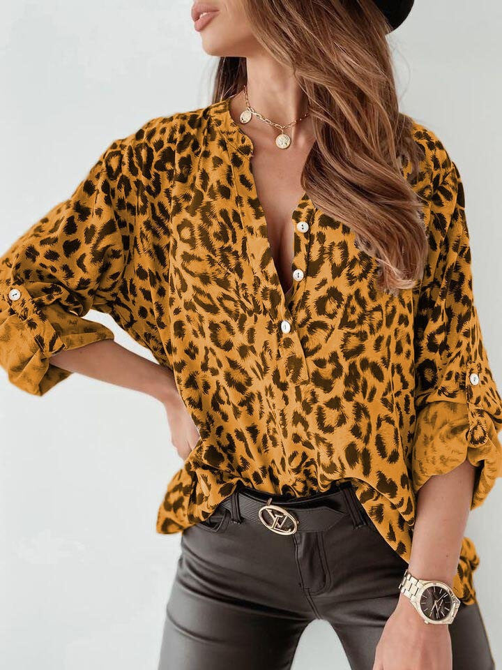 Mustard leopard print henley blouse with rolled sleeves and button detail.