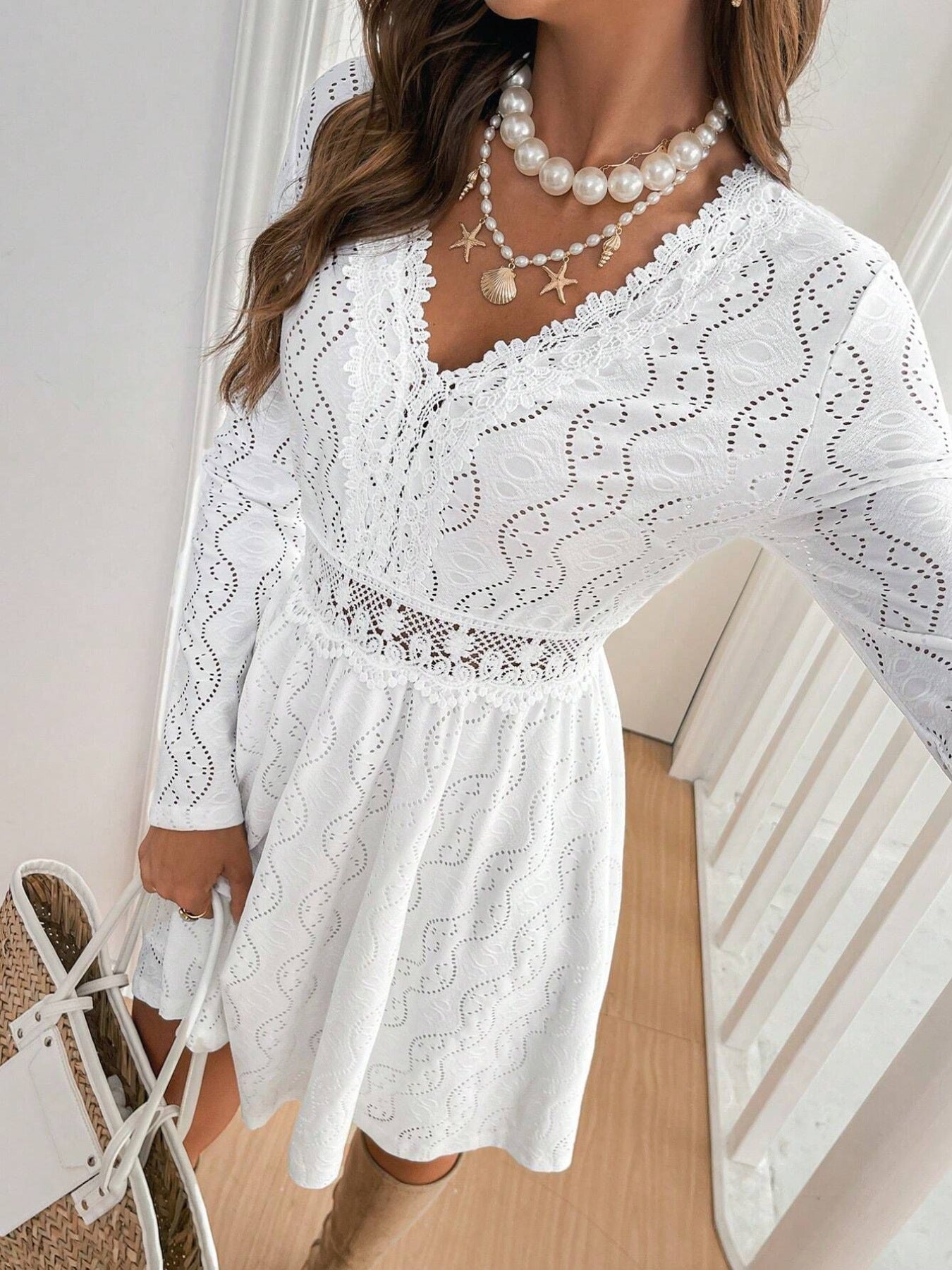 White lace openwork V-neck dress with long sleeves and a-line skirt.