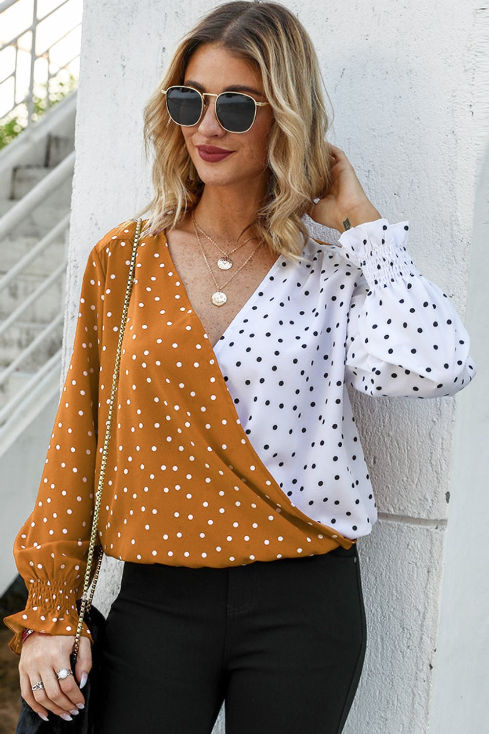 Colorblock polka dot wrap blouse in tangerine and white with smocked cuffs.