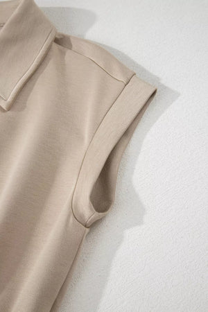 Collared cap sleeve romper in beige with folded cuffs.