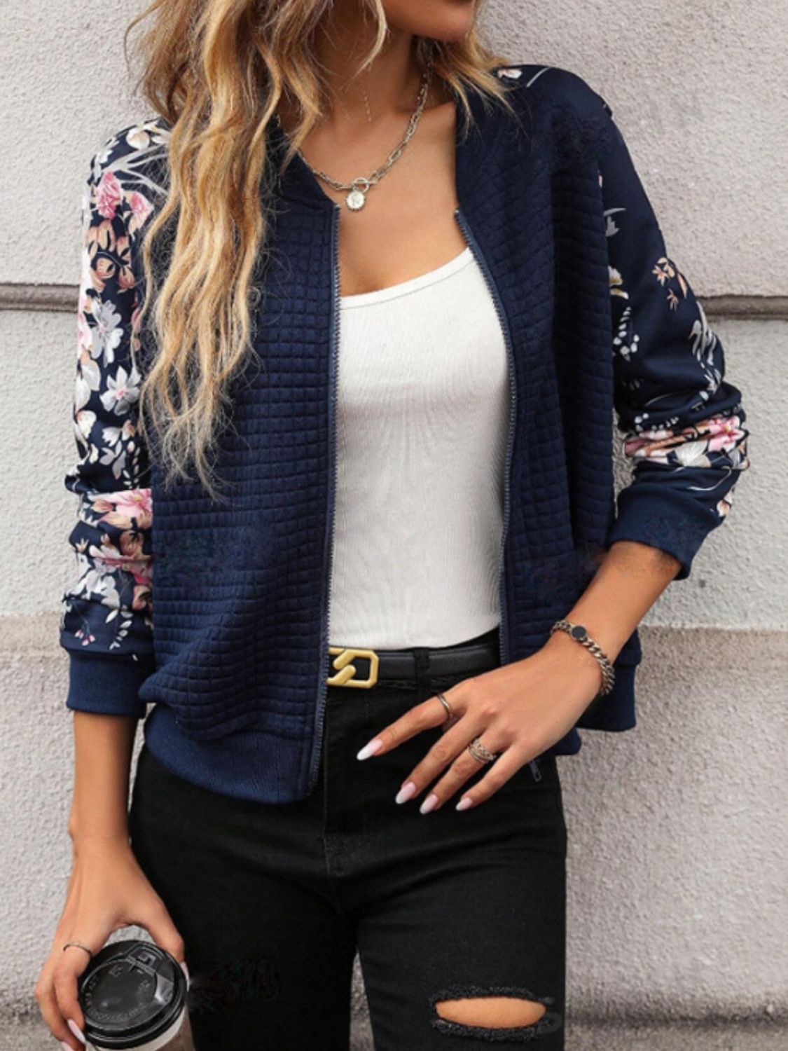 Navy quilted bomber jacket with floral sleeves and a zip front.