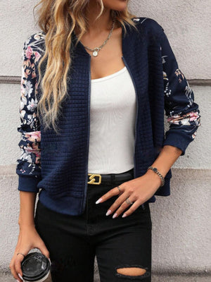 Navy quilted bomber jacket with floral sleeves and a zip front.