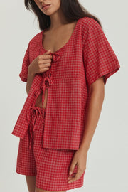 Deep red plaid cotton open-front top with tie closure and matching shorts.