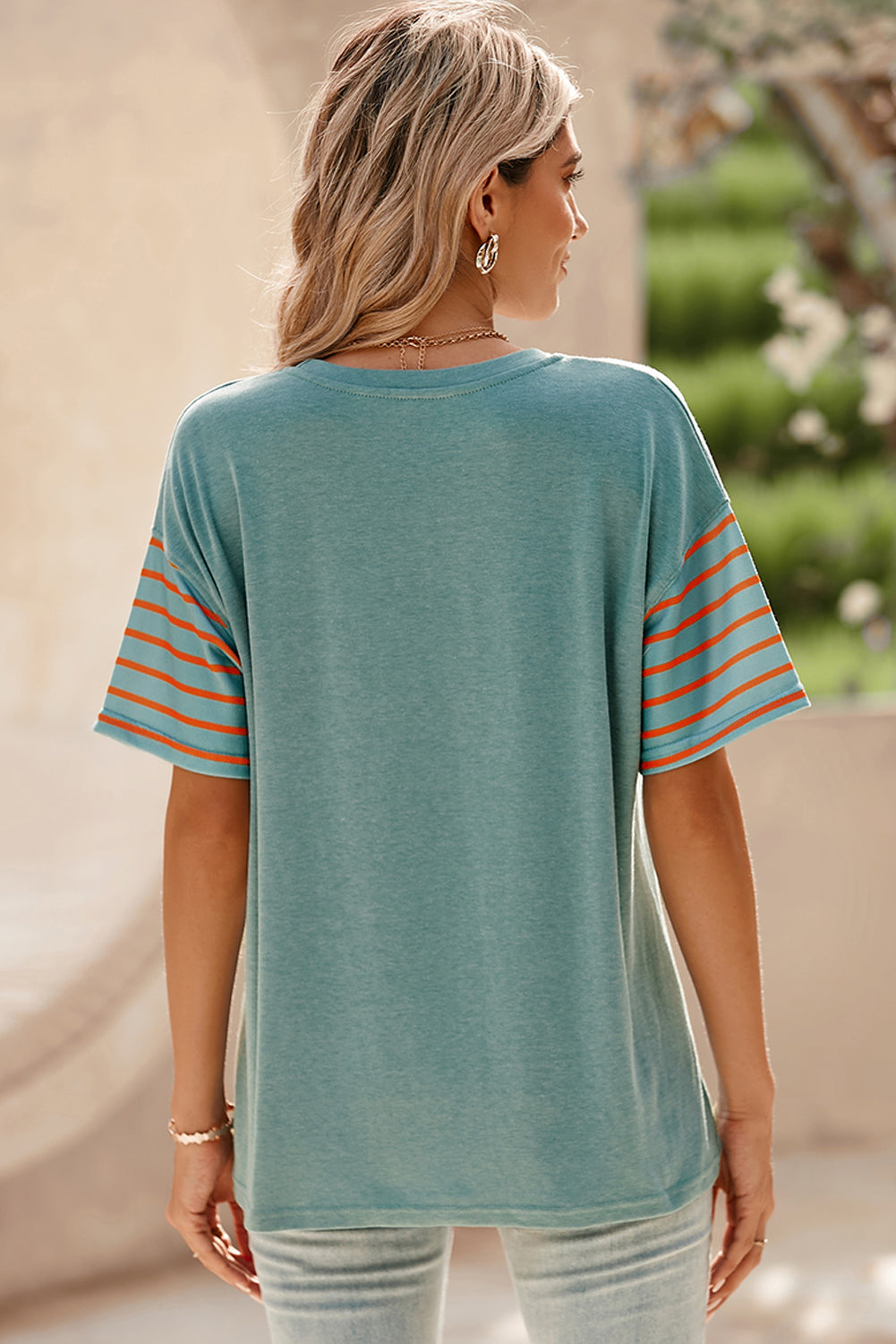 Turquoise raglan tee with orange striped sleeves and side slits