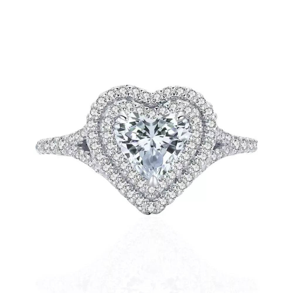 Silver ring with a heart-shaped moissanite center stone and a double diamond halo.