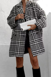 Oversized houndstooth cocoon coat in black and white with a notched collar and front pockets.
