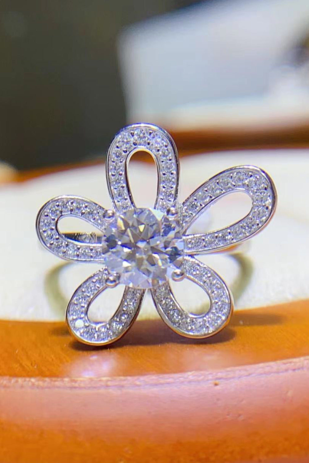 White moissanite ring with pavé petals in a flower design.