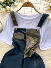 White knotted tee and distressed denim overalls ensemble with embroidered detail