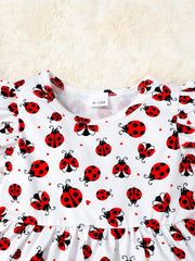 Baby set with white fabric, red ladybug print, and ruffle trim sleeves.