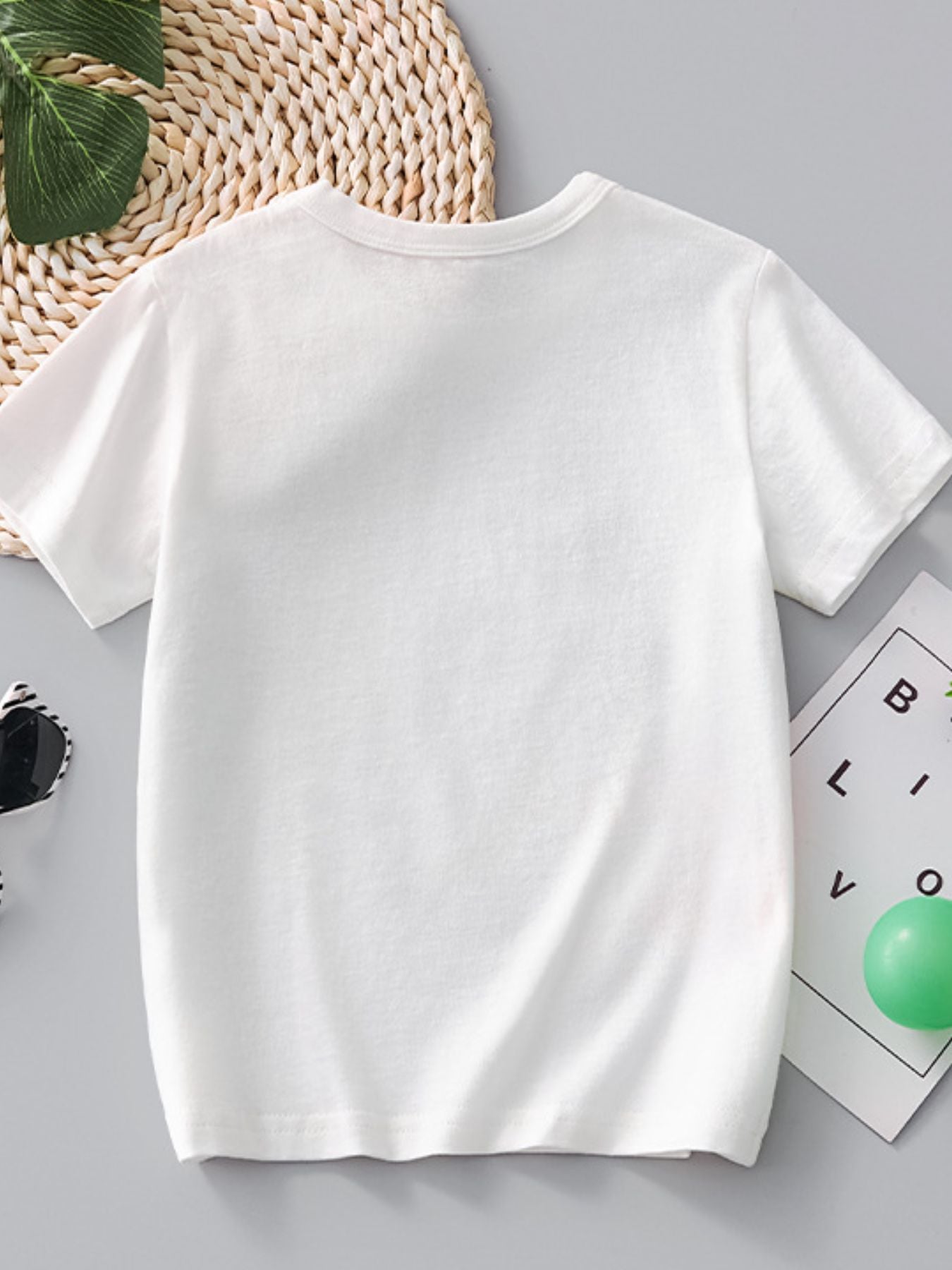 White cotton crew-neck t-shirt with short sleeves and a dinosaur print.
