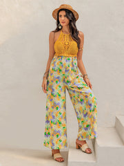 Gold crochet halter jumpsuit with a vibrant floral print and wide palazzo legs.