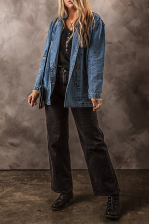 Medium wash denim double-breasted blazer with button closure and flap pockets.