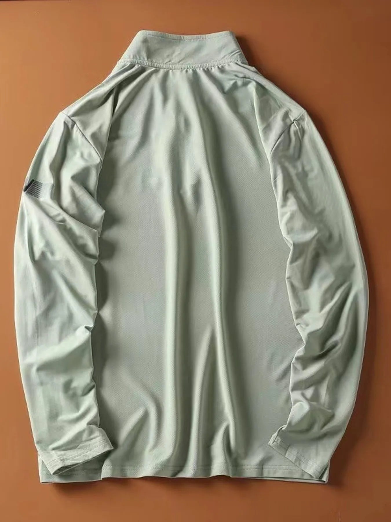 Light green quarter-zip long-sleeve sweatshirt with a textured fabric and a subtle detail on the left sleeve.