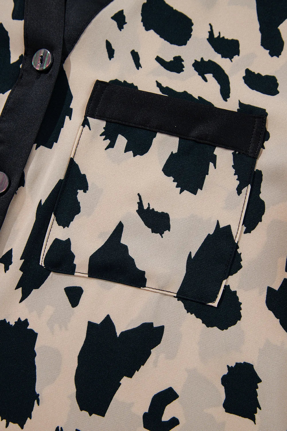 Animal print satin pajama shirt with black trim and pocket detail.