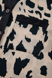 Animal print satin pajama shirt with black trim and pocket detail.