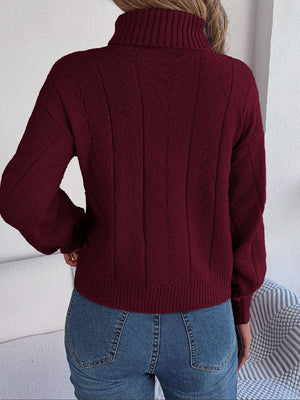 Burgundy cable knit turtleneck sweater with drop shoulder and textured pattern.