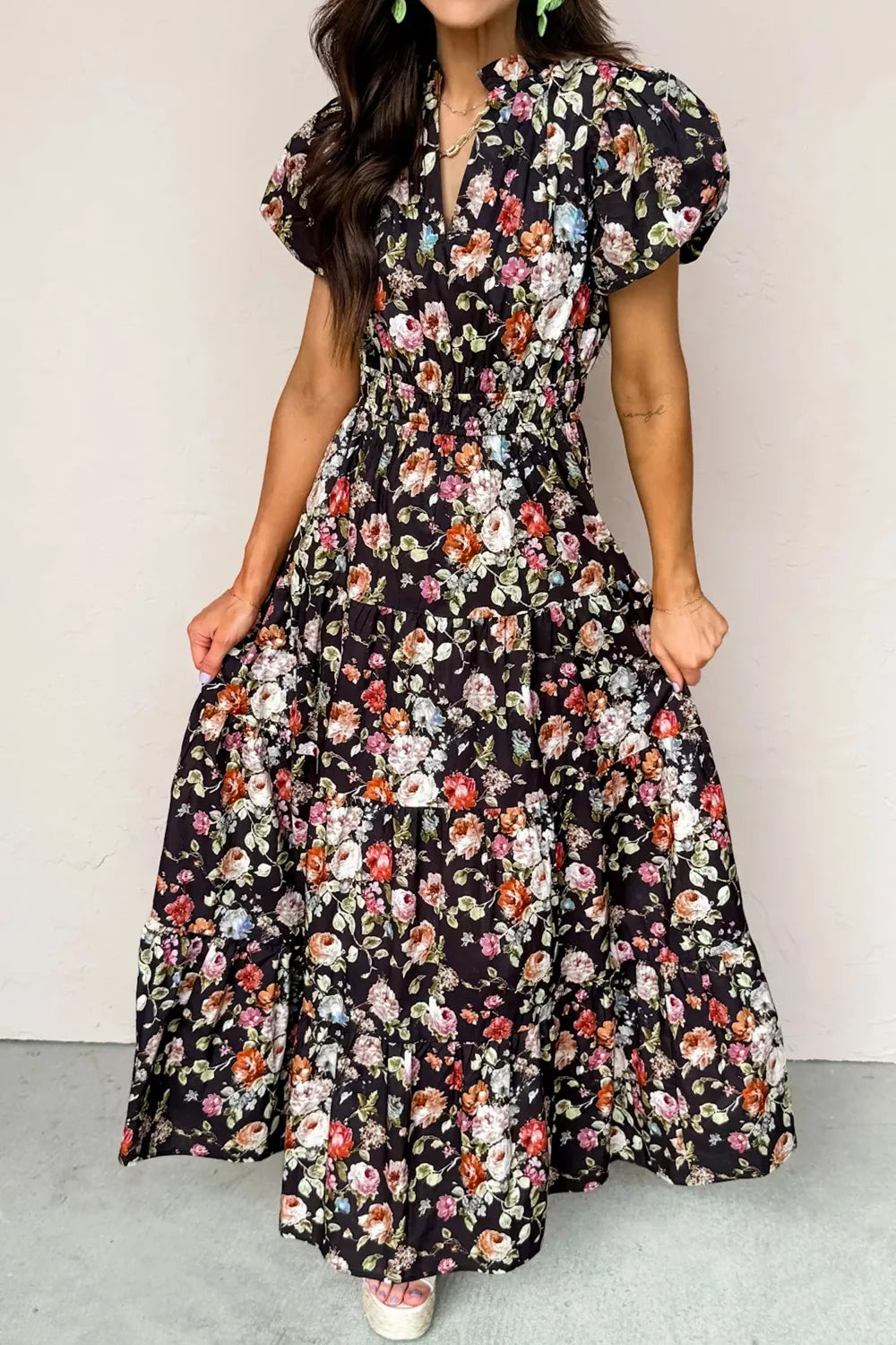 Black floral tiered maxi dress with smocked waist and puff sleeves.
