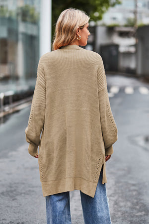 Tan open-knit longline cardigan with side slits and textured sleeves.