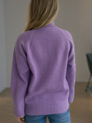 Purple ribbed turtleneck sweater with subtle sparkle detail and cuffed sleeves.
