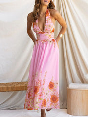 Pink floral halter neck maxi dress with a deep V-neckline and flowing skirt.