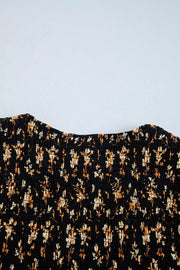 Black floral smocked blouse with a square neckline and long sleeves.