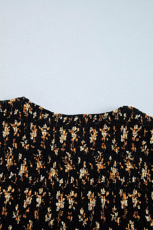 Black floral smocked blouse with a square neckline and long sleeves.