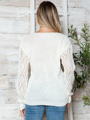 White openwork knit sweater with lace trim detail on sleeves.