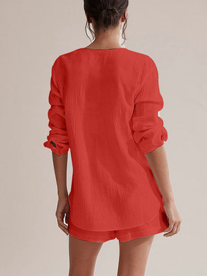 Textured cotton pajama set in orange-red with button-up top and shorts.