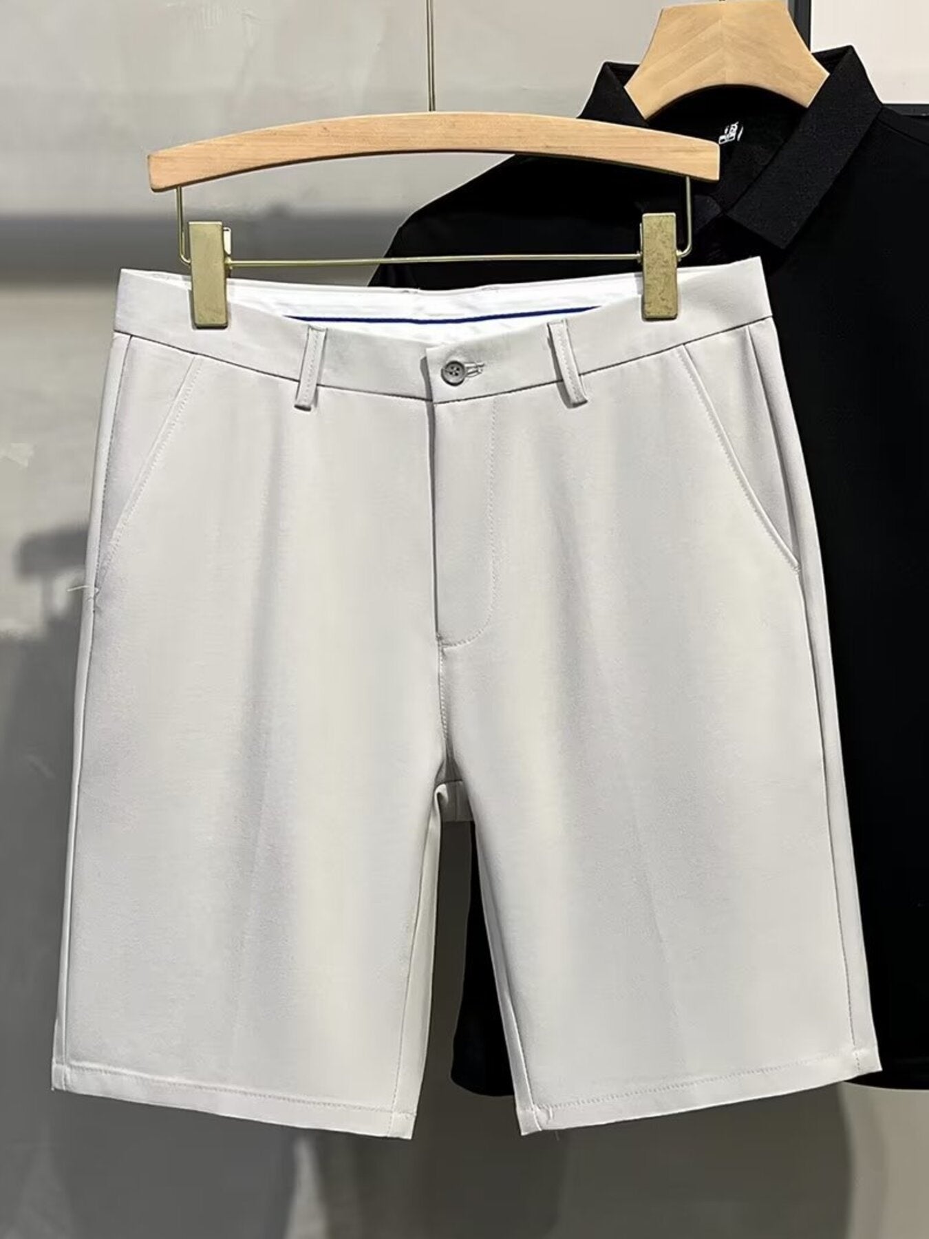 Men's light gray chino shorts with a button and zip fly, classic pockets.