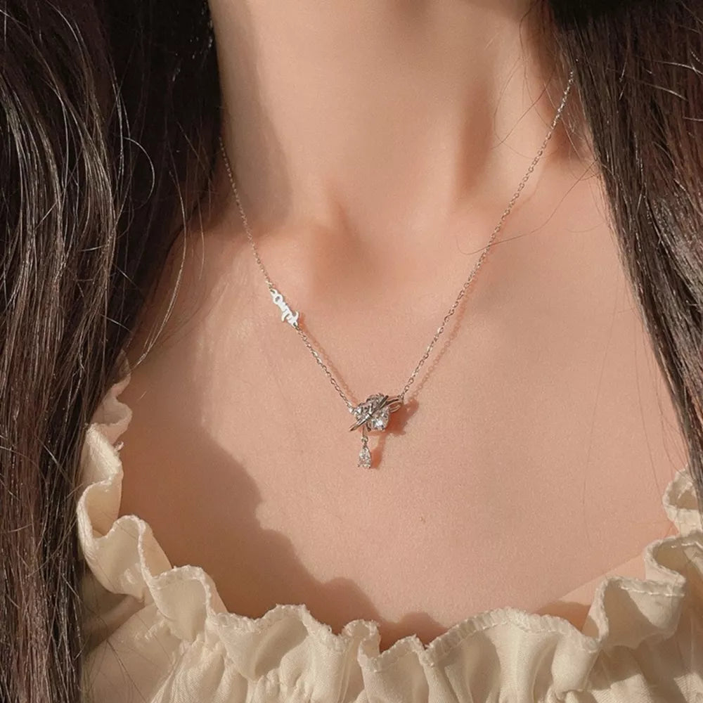 Elegant silver necklace with a zircon heart pendant and a dangling crystal teardrop.