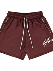Burgundy jogger shorts with drawstring, zip pockets, and white script logo detail.