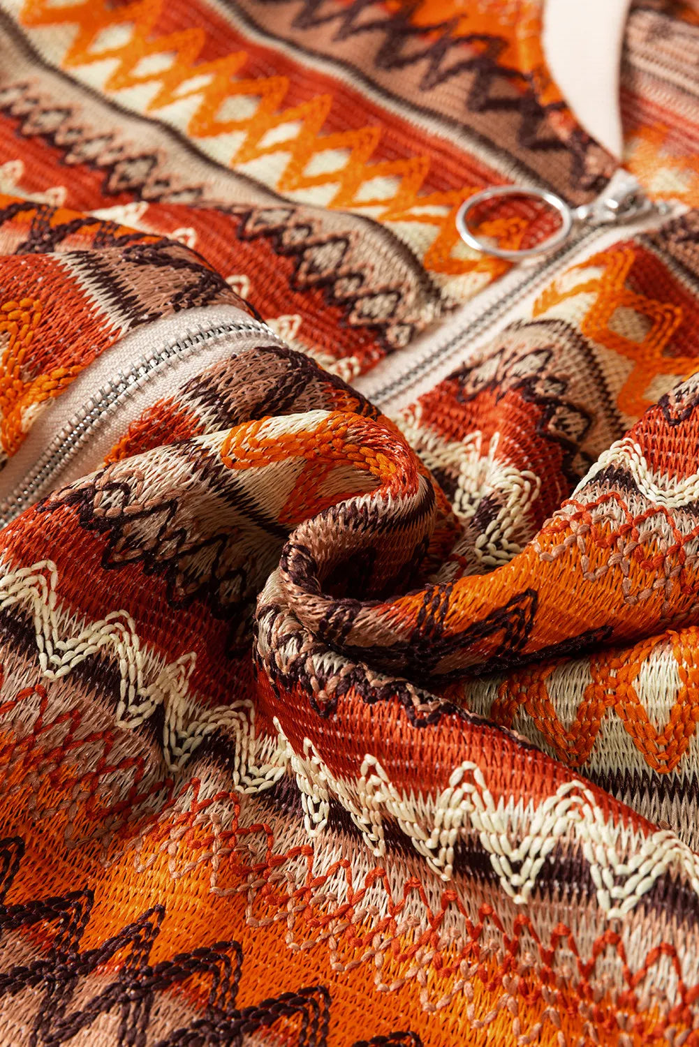 Orange geometric knit bomber jacket with a zipper detail.