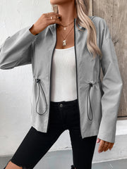 Gray utility jacket with cinched waistline and black trim, worn open over a white tank top.
