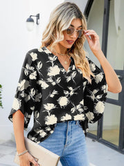 Black floral print blouse with v-neck and flutter sleeves, made of 100% polyester.