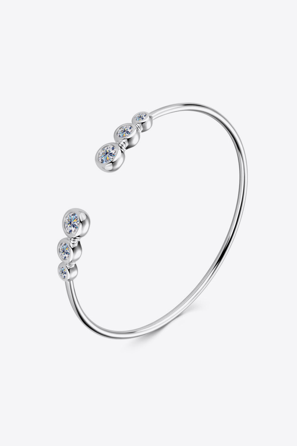 Silver open-ended cuff bracelet with five round moissanite stones.