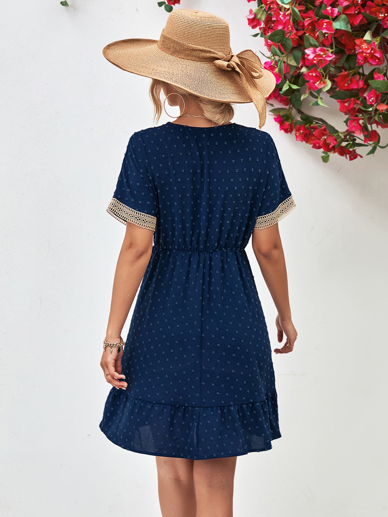 Dark blue Swiss dot dress with crochet trim sleeves and ruffled hem.