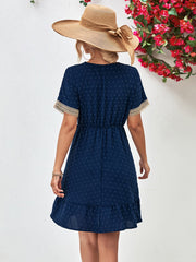Dark blue Swiss dot dress with crochet trim sleeves and ruffled hem.
