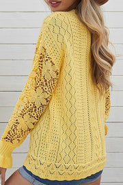 Yellow openwork knit sweater with lace sleeves and diamond pattern.