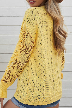 Yellow openwork knit sweater with lace sleeves and diamond pattern.