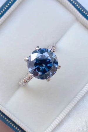 Midnight blue solitaire engagement ring with a pavé band.