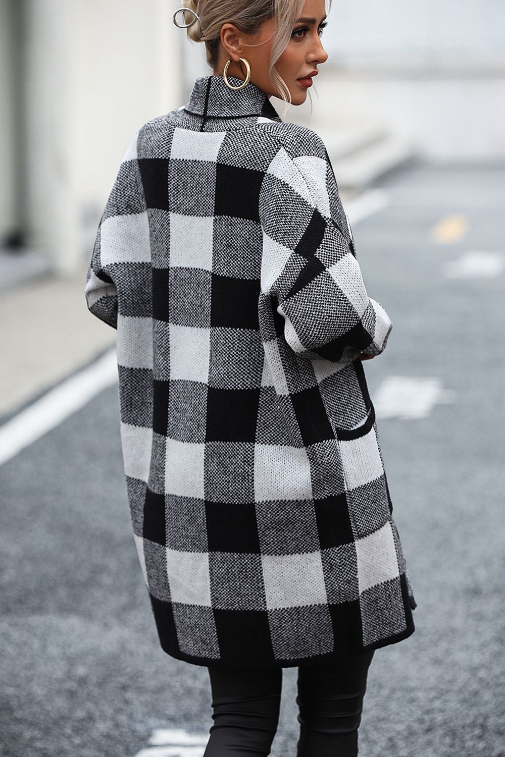 Black and white checkerboard knit duster coat with pockets and a collar.