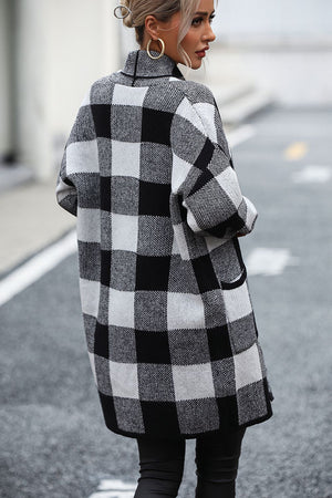 Black and white checkerboard knit duster coat with pockets and a collar.