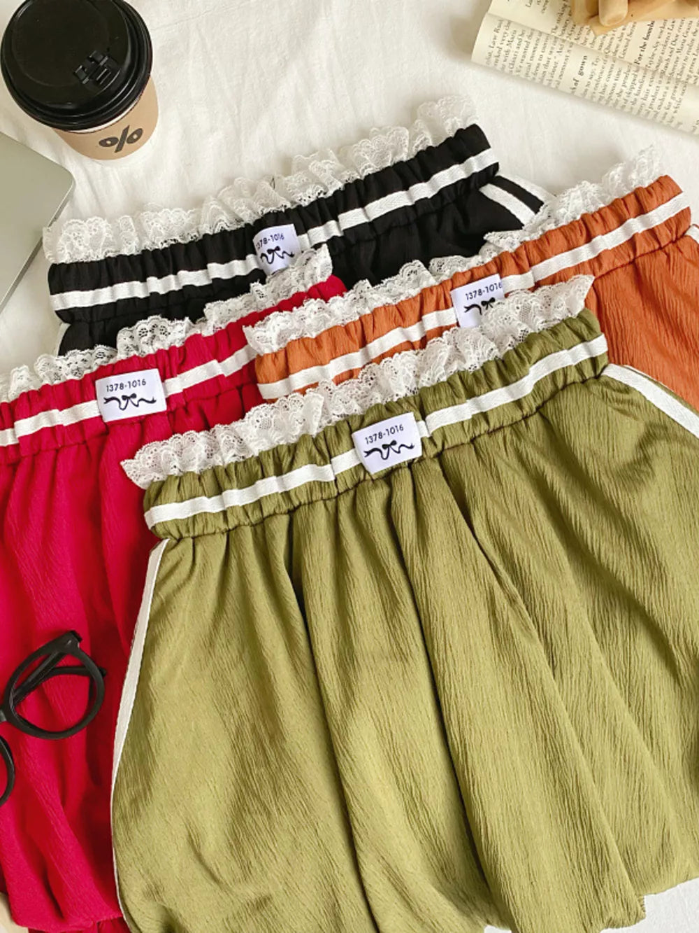 Lace-trimmed gathered waist mini skirts in red, army green, orange, and black with white stripe detail.