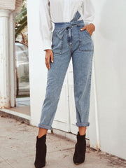 Light wash denim paperbag waist tapered trousers with tie belt and cuffed hems.