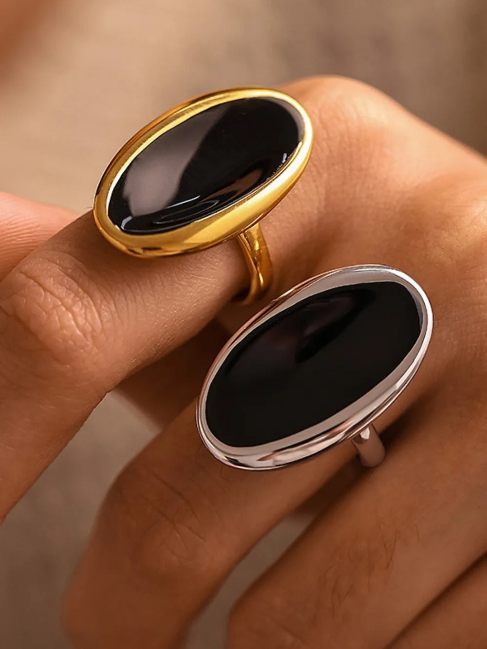 Sculpted oval onyx cocktail rings in gold and silver settings.